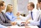 Businesswoman and businessman arm wrestling