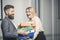 Businesswoman and businessman with folders. Man help woman to carry binders in office. Bearded man and girl with