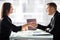 Businesswoman and businessman shaking hands over the table with laptop and papers at the office, pleasant business meeting, starti