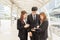 Businesswoman and businessman standing outside office and talking to each other.