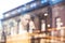 Businesswoman at a cafe, having coffee and looking at tablet. Window reflections of european architecture