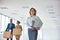 Businesswoman carrying files while colleagues talking with cardboard boxes at new office