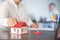 Businesswoman choosing mini house model from model on wood table