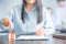 Businesswoman choosing mini house model from model on wood table