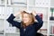 Businesswoman Clenching Teeth While Placing Documents On Head