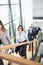 Businesswoman Climbing Stairs With Colleagues In Modern Office