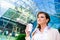 Businesswoman with coffee cup against glassy modern office build