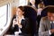 Businesswoman Commuting To Work On Train Using Mobile Phone