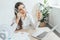 businesswoman cooling herself with electric fan hand fan and bottle of water at workplace with documents