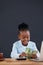 Businesswoman counting paper currency while using laptop