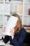 Businesswoman Covering Face With Documents At Desk