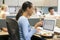 Businesswoman in cubicle eating sushi smiling