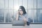 Businesswoman with damaged laptop by the window