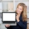 Businesswoman Displaying Laptop With Blank Screen In Office