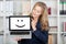 Businesswoman Displaying Smiley Face On Laptop\'s Screen