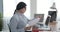 Businesswoman doing paperwork and using laptop at office