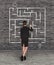 Businesswoman drawing labyrinth on wall