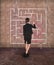 Businesswoman drawing labyrinth on wall