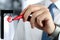 Businesswoman drawing a virtual gibbet with euro by a red pen