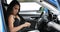 Businesswoman driver prepares for driving getting in car