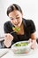 Businesswoman eating salad at desk