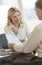 Businesswoman Explaining Report To Colleague In Office