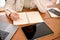 A businesswoman or female office employee listing her work list on a notebook