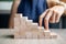 Businesswoman finger step on wooden block building