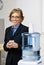 Businesswoman getting water from water cooler