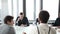 Businesswoman giving presentation, coleaguess sitting at table and clapping