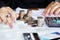 Businesswoman hand counting on saving account with stack of coins