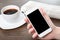 Businesswoman hand holding a phone in the office