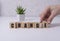 Businesswoman hand holding wooden cube with flip over block CHANGE to CHANCE word on table background. success, strategy