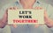 Businesswoman hands holding card sign with let\'s work together