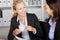 Businesswoman Having Coffee While Looking At Coworker