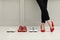Businesswoman in high heel shoes standing near different comfortable sneakers indoors, closeup