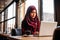 Businesswoman in hijab working from a coffee shop