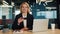 Businesswoman holding bank credit card looking into camera in office.