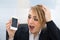 Businesswoman holding broken smartphone