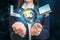 Businesswoman holding digital image of Earth and different devices in hands on color background, closeup