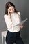 Businesswoman holding his head reading documents. on gray background. Portrait of businesswoman.