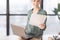 Businesswoman Holding Laptop And Documents Sitting On Office Table