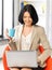 Businesswoman at home with laptop and cup