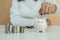 Businesswoman or housekeeper is putting coins in a piggy bank with coins piled on the table. woman to collect savings as a busines