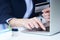 Businesswoman inputting her password and login to carry out online banking operation on laptop pc in the office. Woman`s