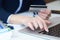 Businesswoman inputting her password and login to carry out online banking operation on laptop pc in the office. Woman`s