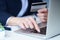 Businesswoman inputting her password and login to carry out online banking operation on laptop pc in the office. Woman`s