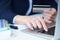 Businesswoman inputting her password and login to carry out online banking operation on laptop pc in the office. Woman`s