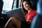 Businesswoman inside her car using a laptop.