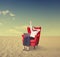 Businesswoman with laptop on chair working in desert